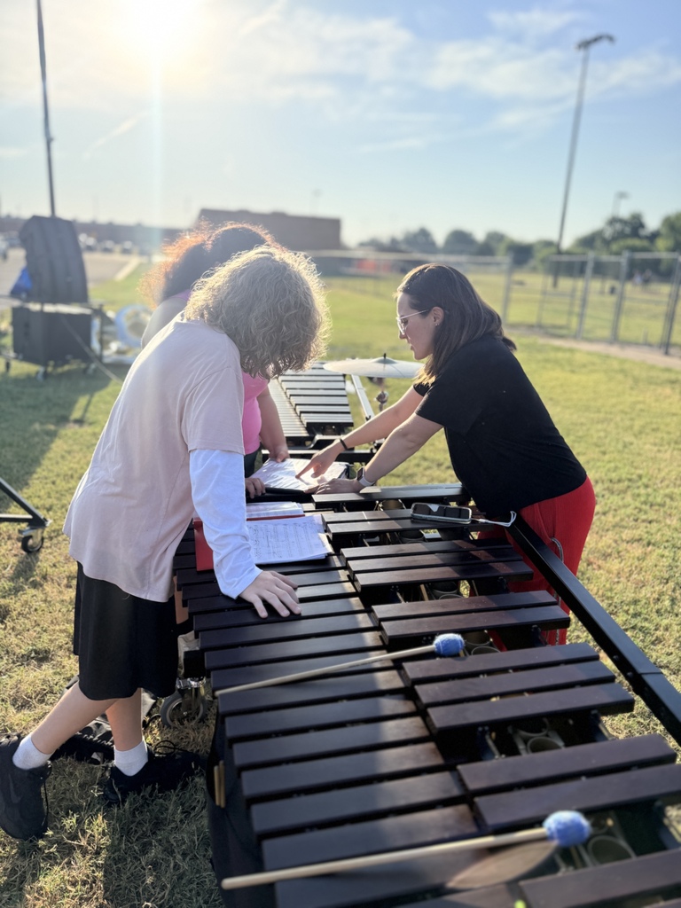 Front line director helping students with their music during a morning rehearsal