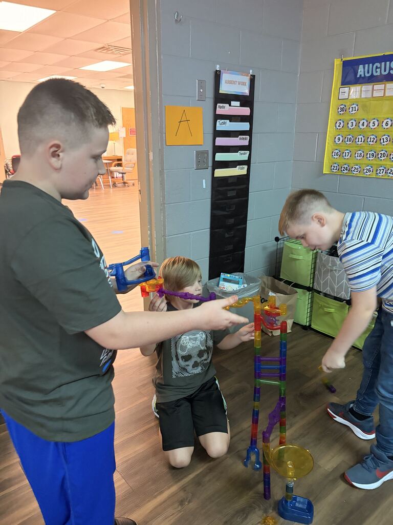 3 male students building something
