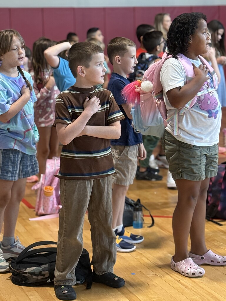 about 10 students saluting the flag