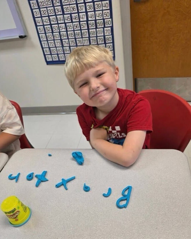 First grade students making their names out of playdough.