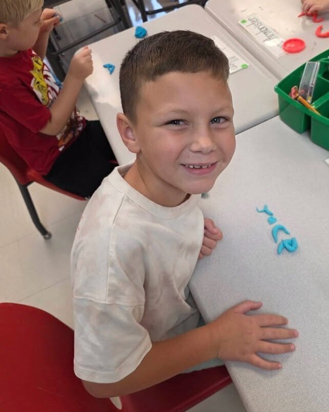 First grade students making their names out of playdough.