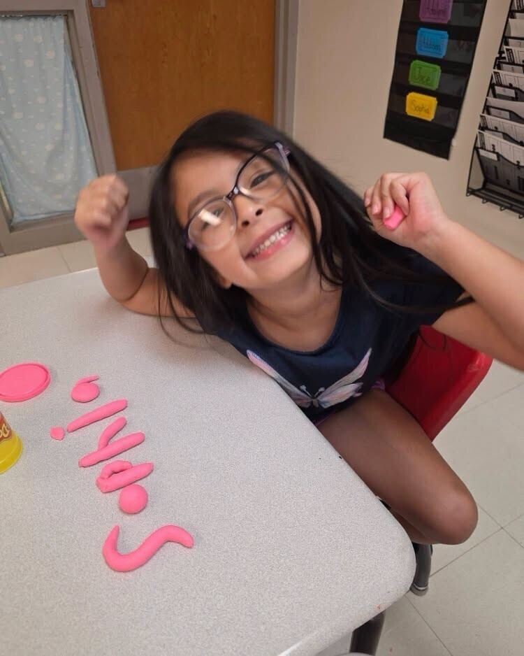 First grade students making their names out of playdough.