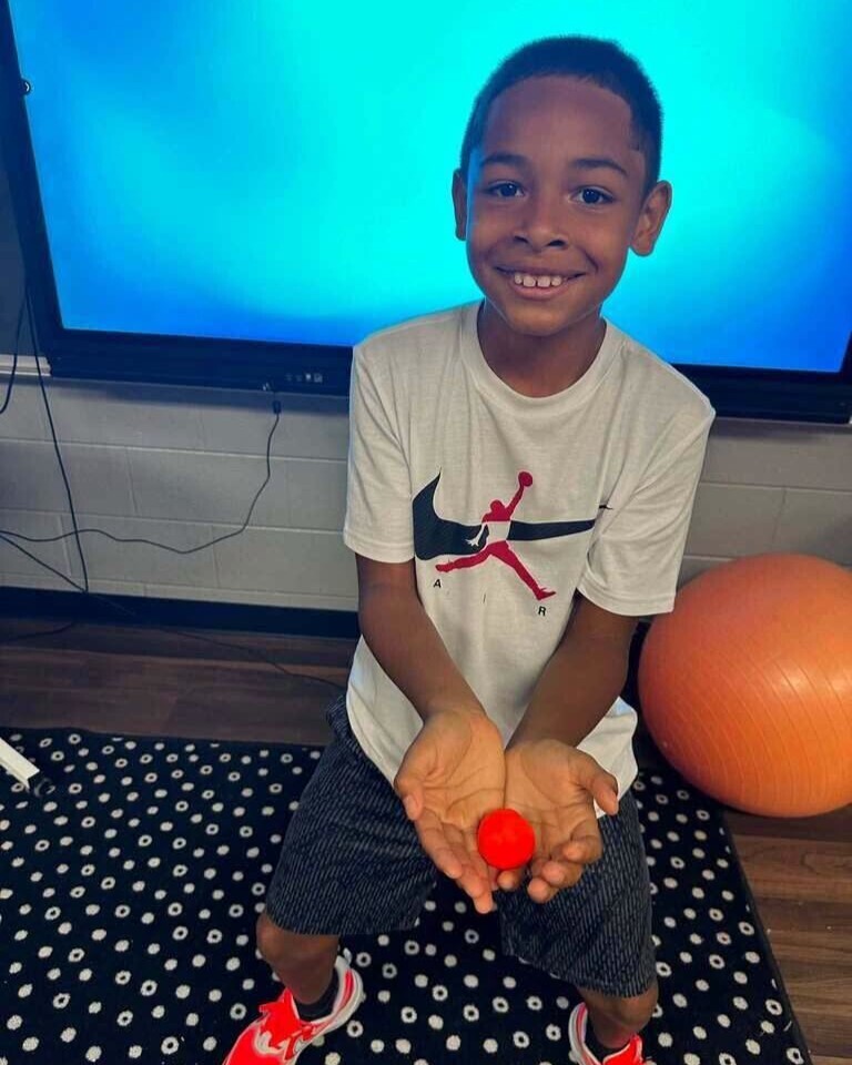 Fourth grade students showing off play doh creation of what brings them joy. 