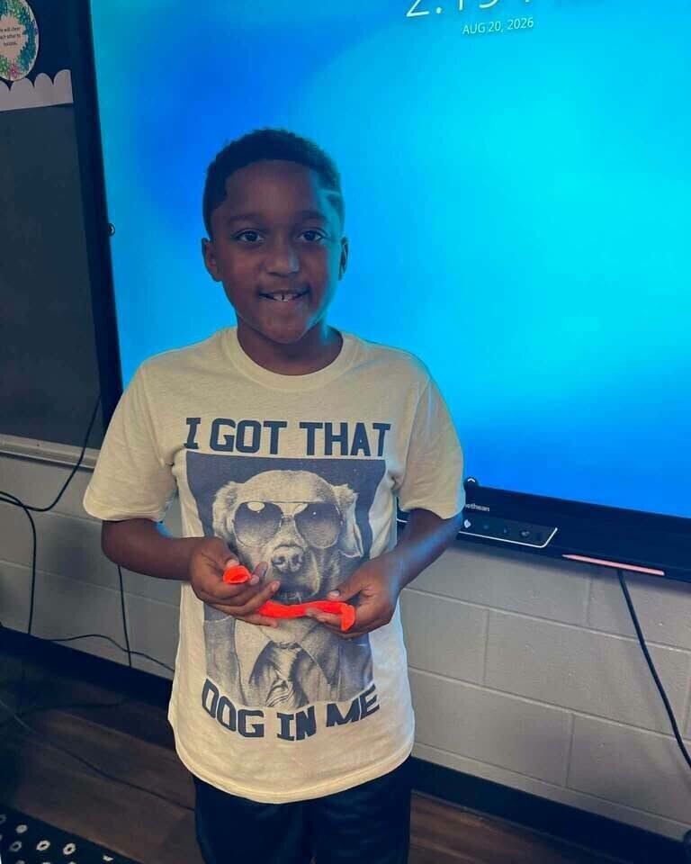 Fourth grade students showing off play doh creation of what brings them joy. 