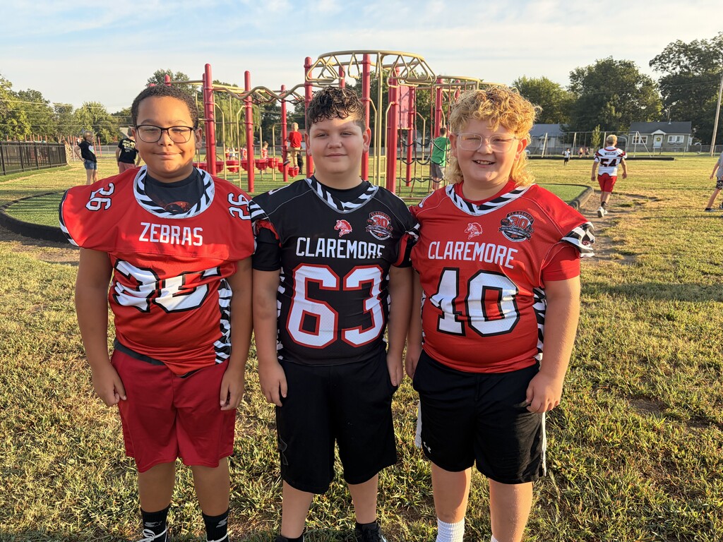 3 boys wearing zebra jerseys, red, black, and red