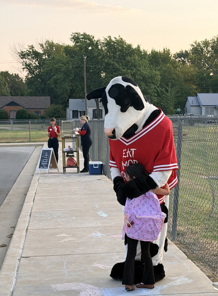 student hugging chick fil a cow