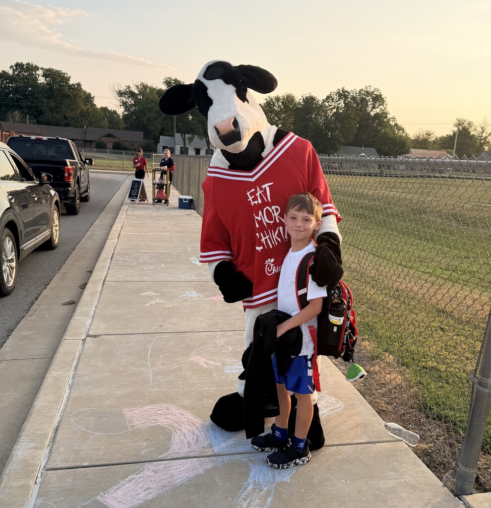 student hugging chick fil a cow