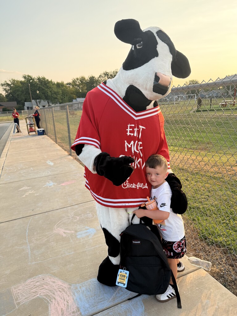 student hugging chick fil a cow