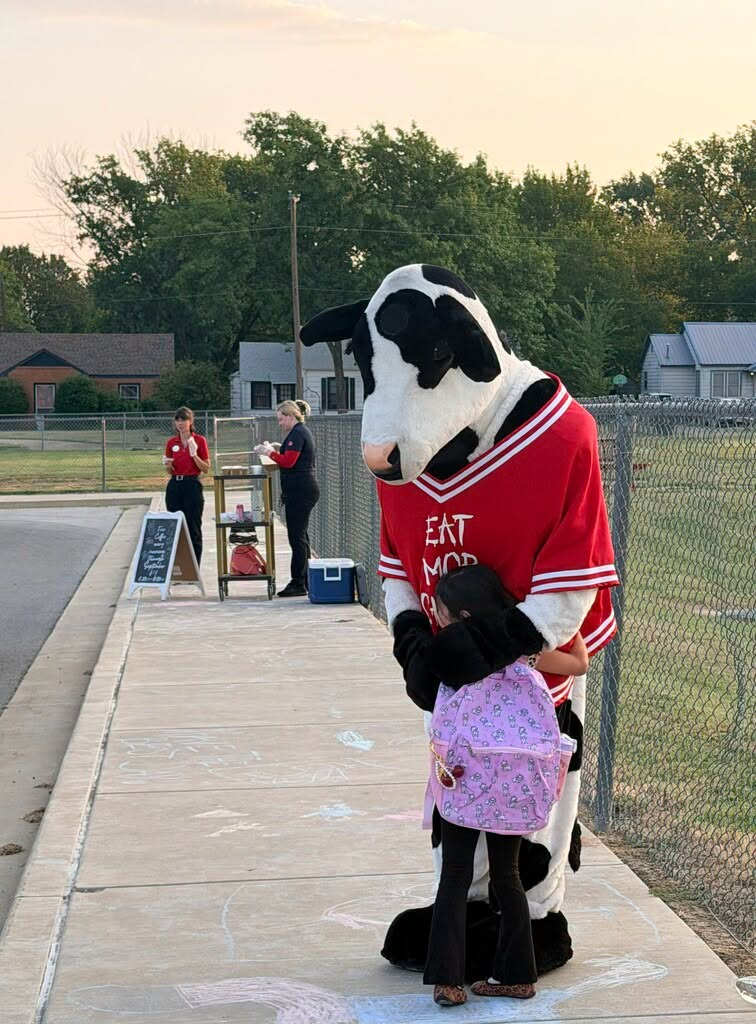 Student hugging cow