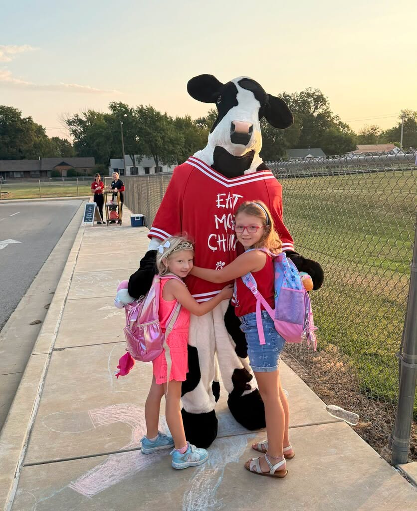 Students hugging cow