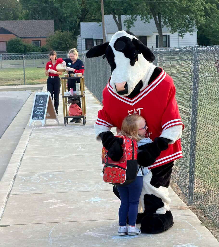 Student hugging cow