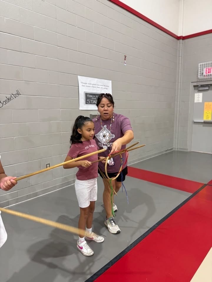 Elementary students learning Cherokee games and instruments.