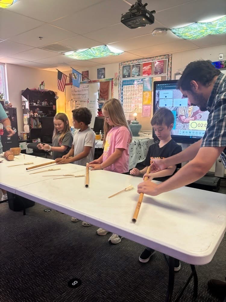Elementary students learning Cherokee games and instruments.