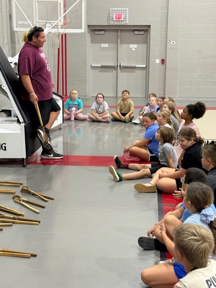 Elementary students learning Cherokee games and instruments.