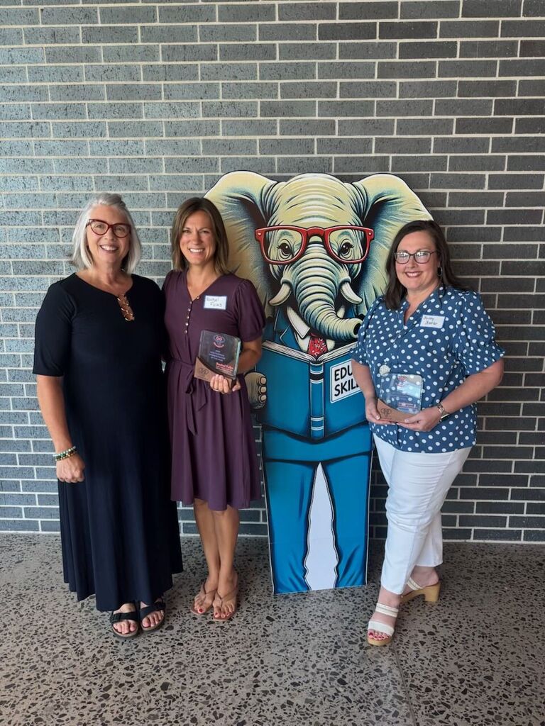staff being recognized and smiling with plaques
