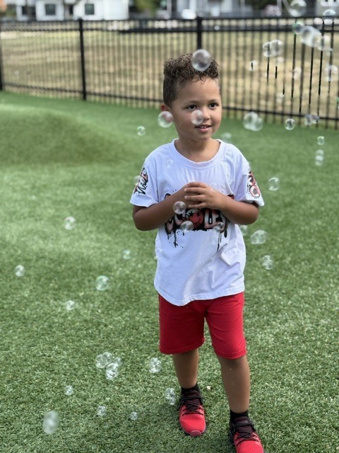 student smiling with bubbles all around him