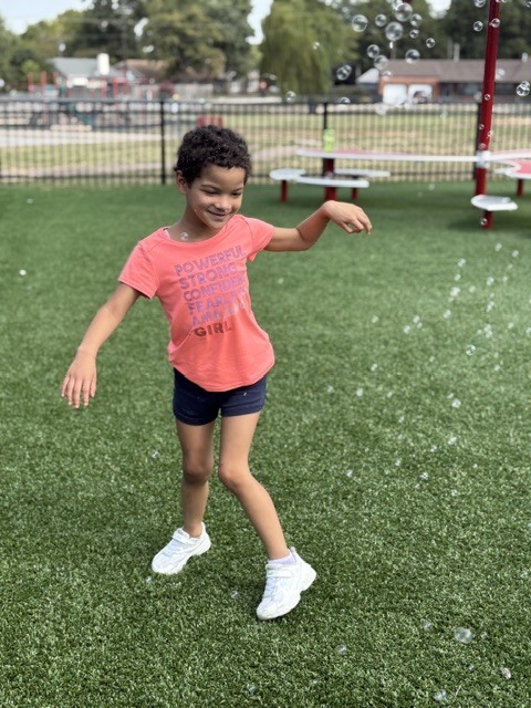 student smiling with bubbles all around him