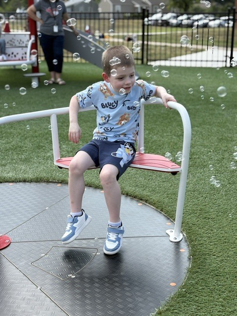 student smiling with bubbles all around him