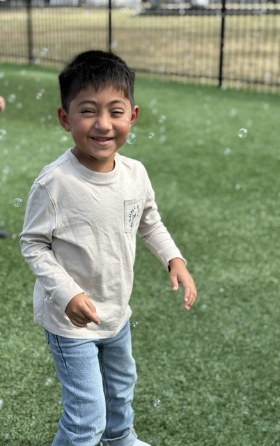 student smiling with bubbles all around him
