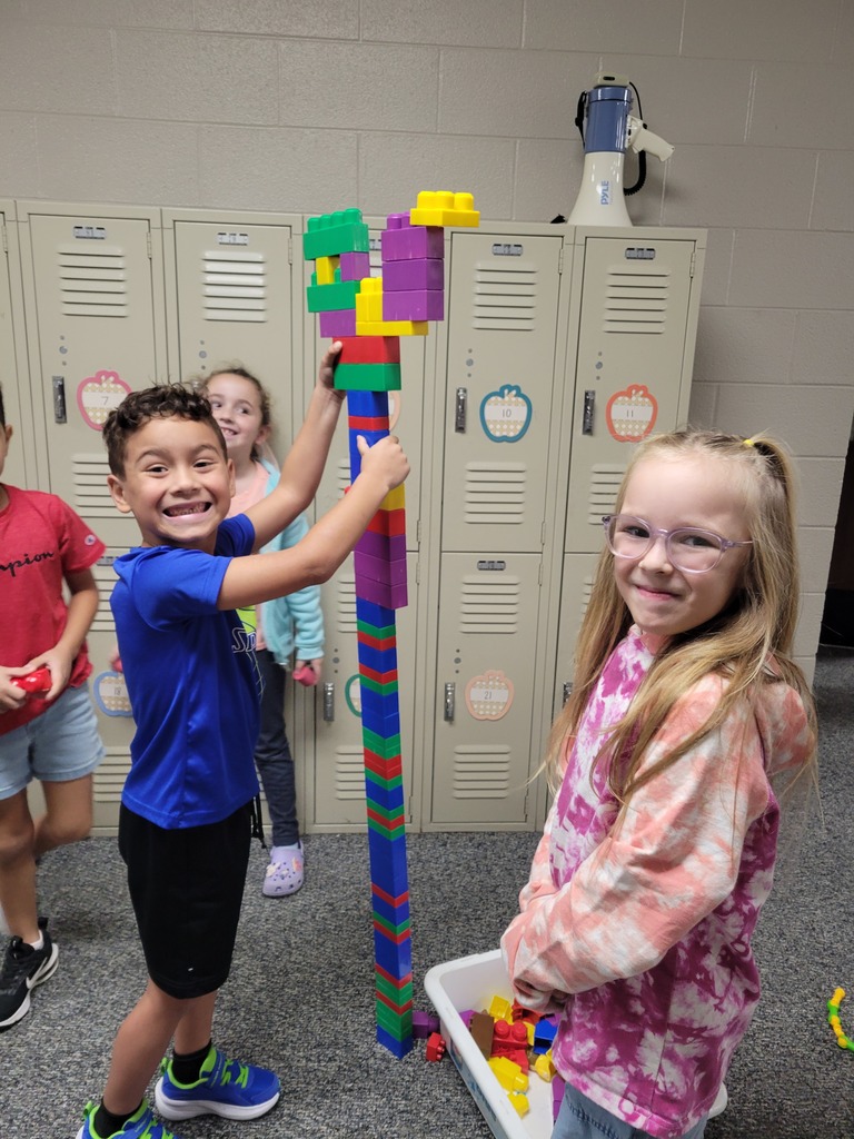 four students building tall blocks