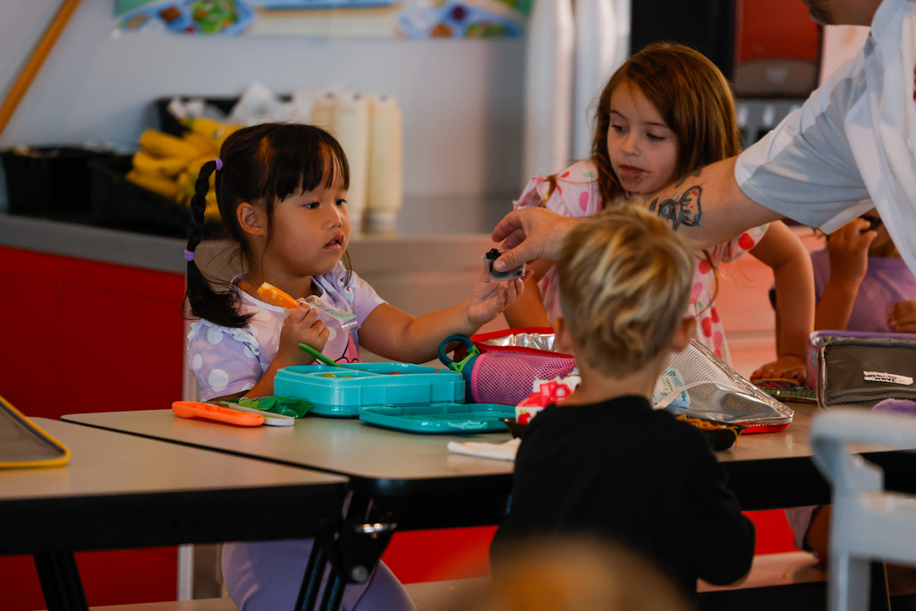 Elementary student perplexed by the sight of squid ink pasta.