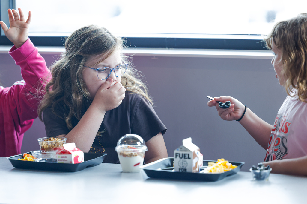 Elementary student perplexed by the sight of squid ink pasta.