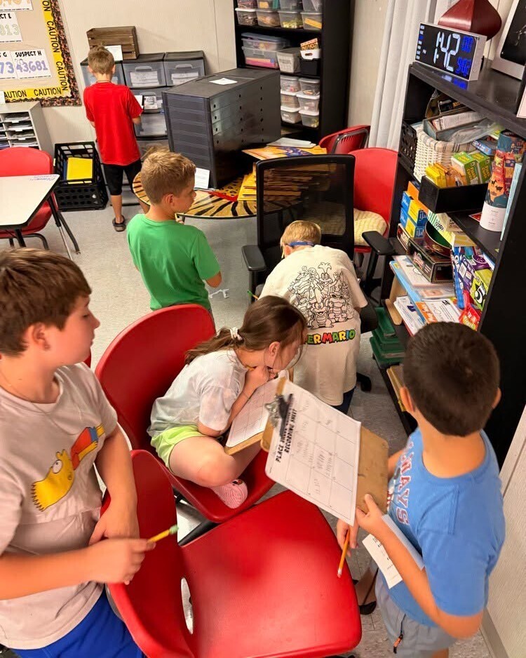 Elementary students working together to solve math activity.
