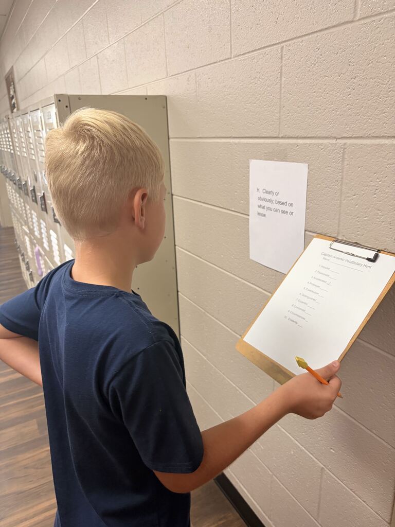 student looking at scavenger hunt paper