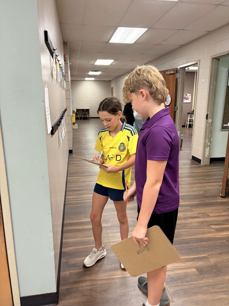 students looking at scavenger hunt paper