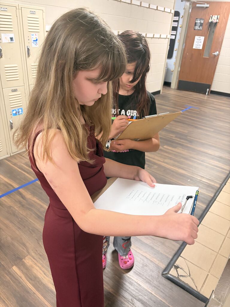 student looking at scavenger hunt paper