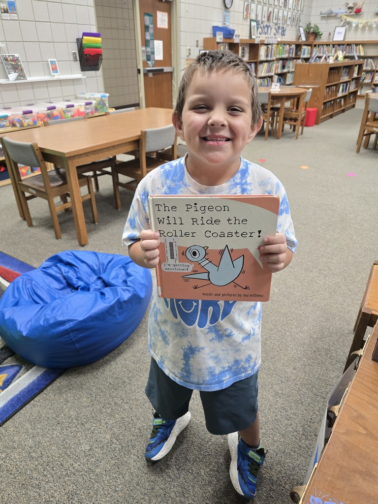 student holding book, smiling