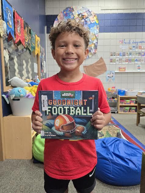 student holding book, smiling