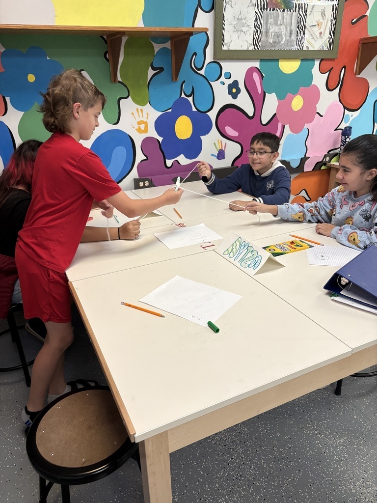 Students working together in art class to make a unique drawing.