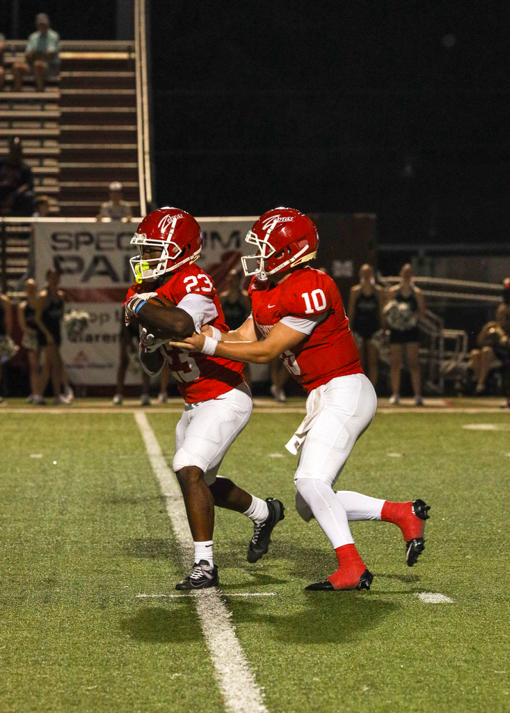 Football players doing a handoff