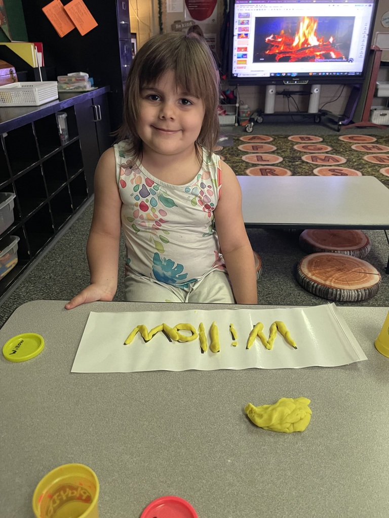 student spelling name with playdoh