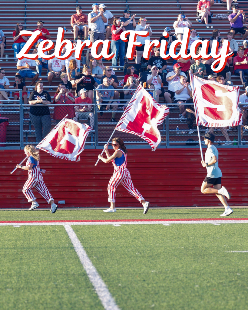 Students running with the CHS flags before the game