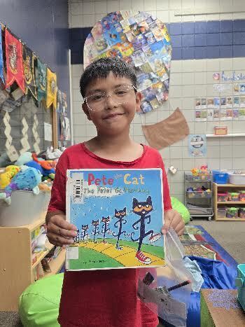 student holding book, smiling