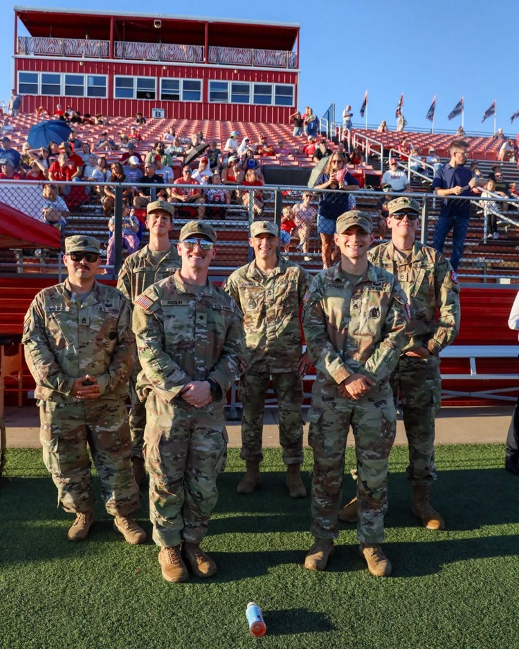 Military in camo on turf.