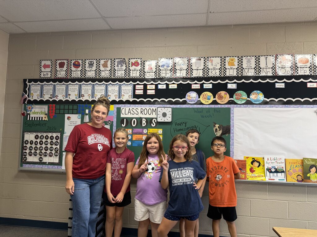 students smiling with teacher wearing sporting gear