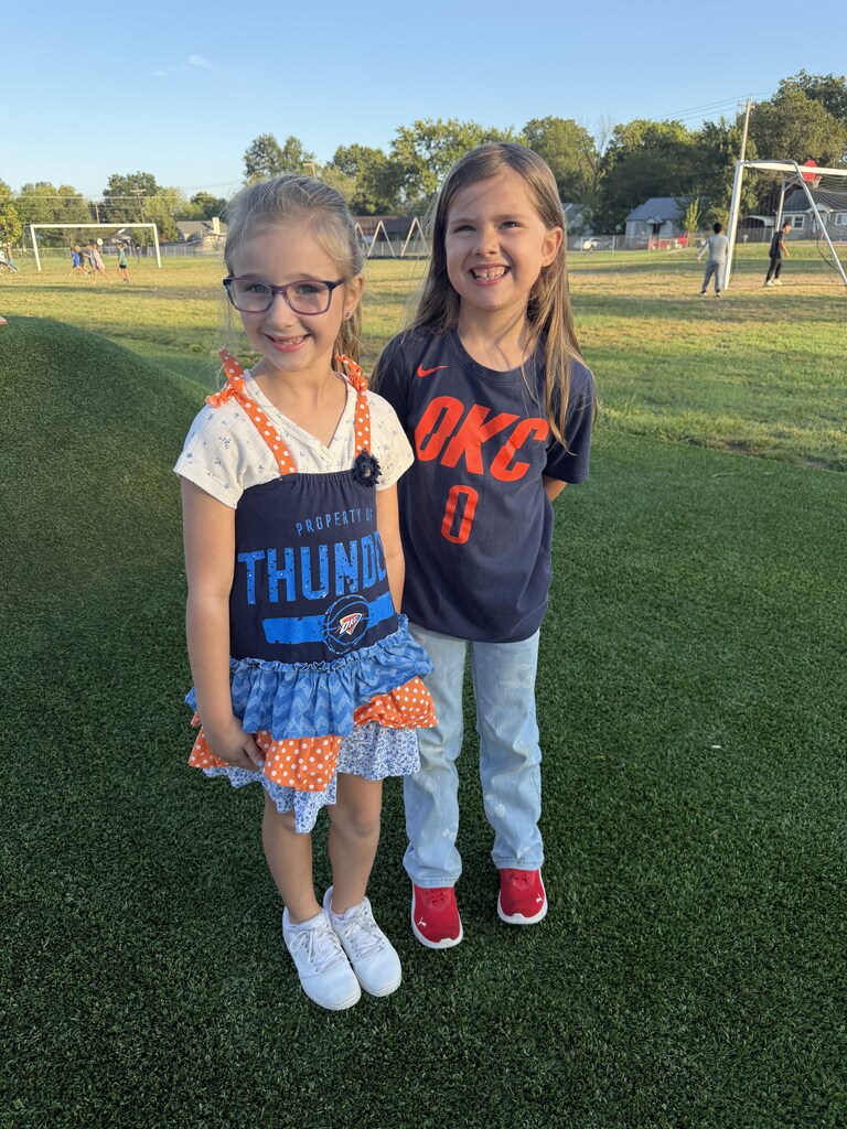students smiling and wearing sport team clothing