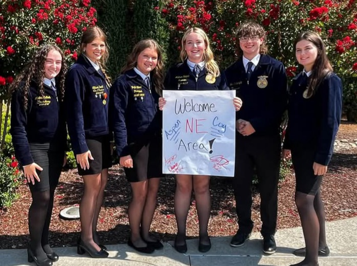 FFA officers in official dress holding a sign