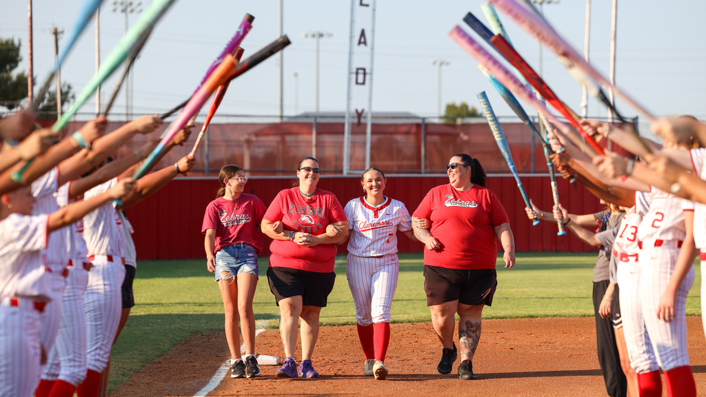 Player and family walking through bat arch