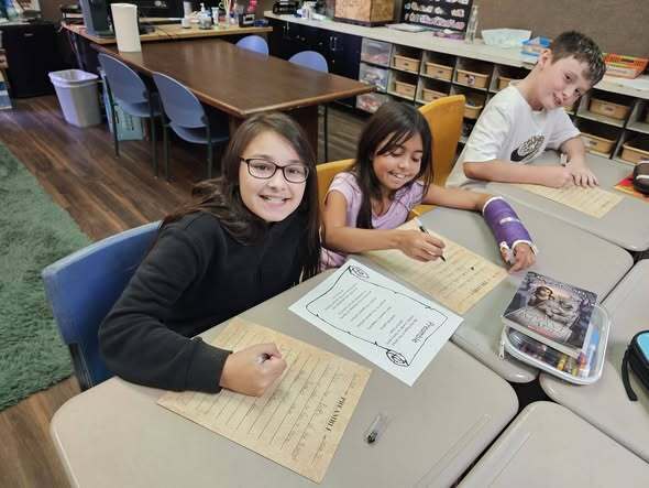 students smiling and writing the preamble