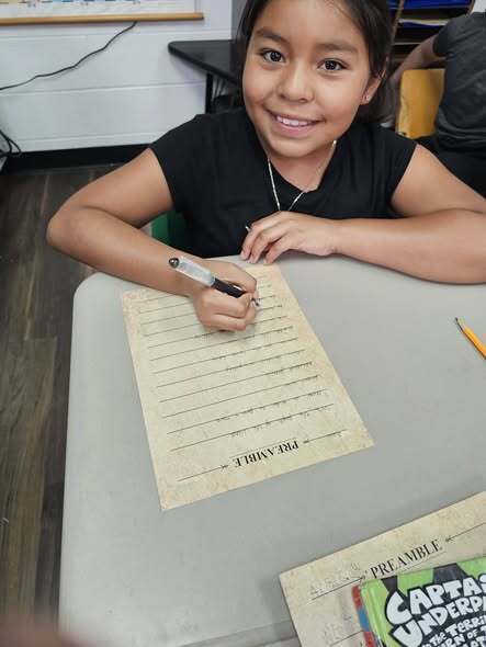 students smiling and writing the preamble
