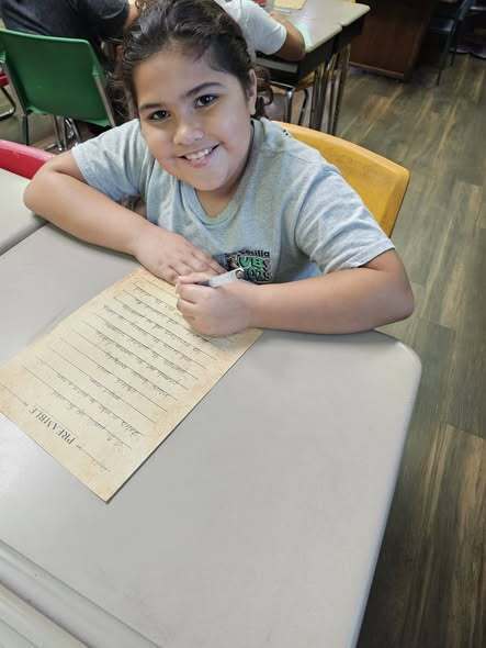 students smiling and writing the preamble