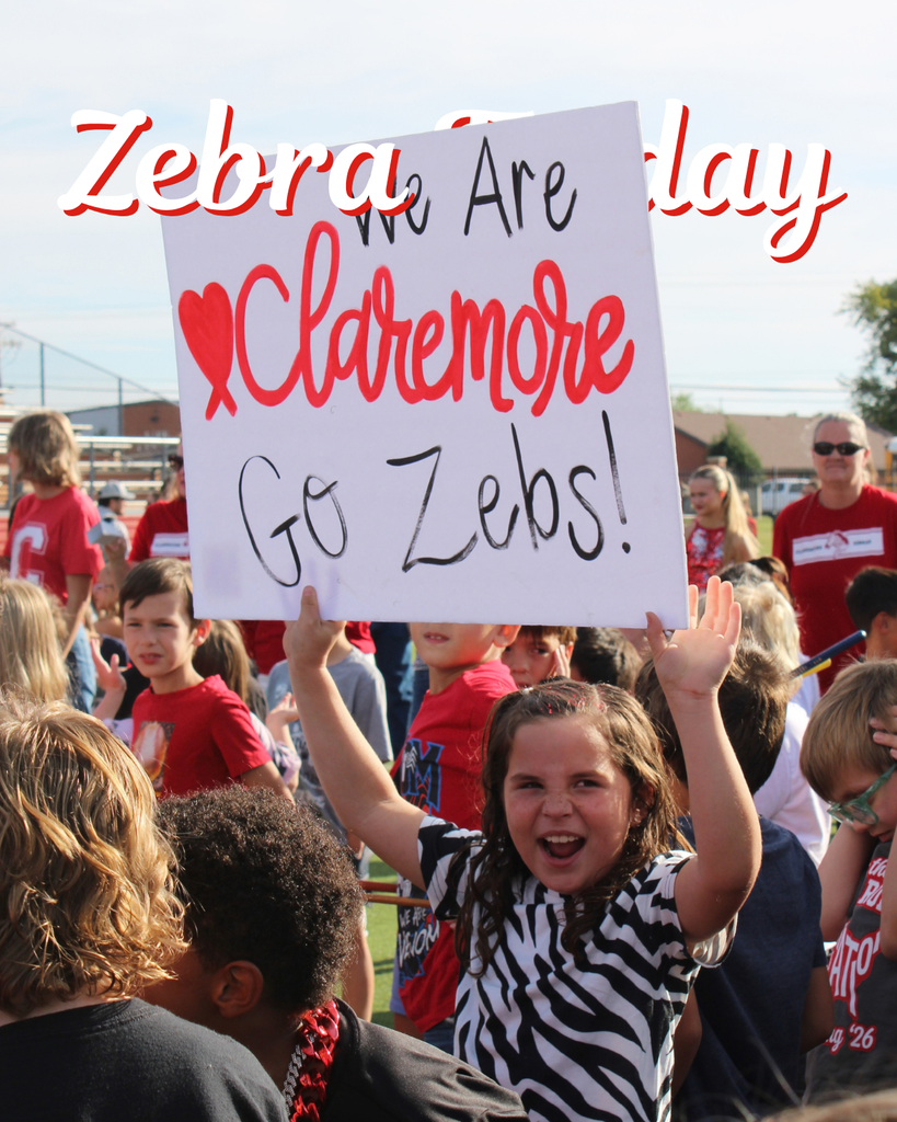 Elementary student holds a “We Are Claremore — Go Zebs!” sign during Homecoming.