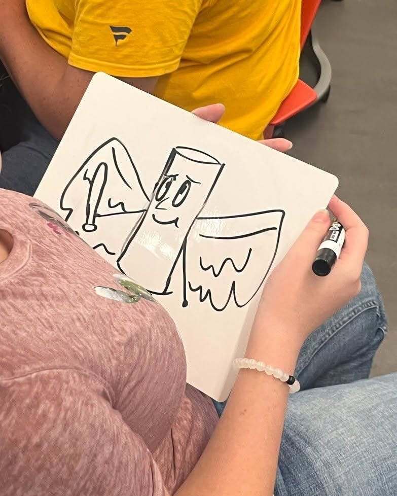 Student drawing on a white board 