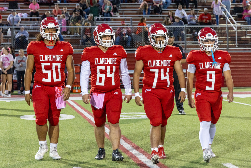 Zebra football players walk across the field during Pink Out.