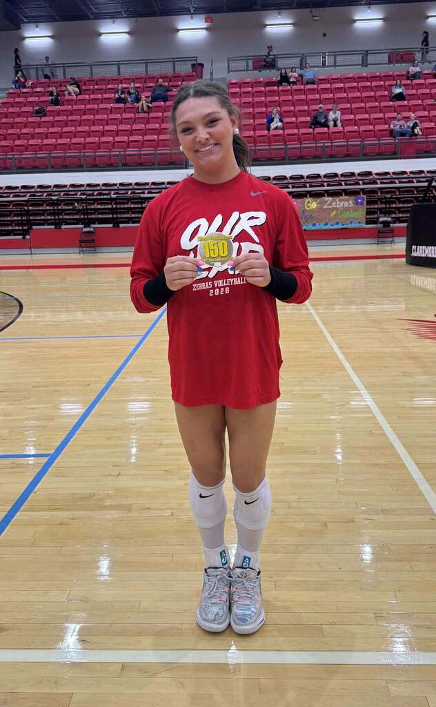 Addison Doyle holds her 150 career blocks milestone sticker in the CHS gym.