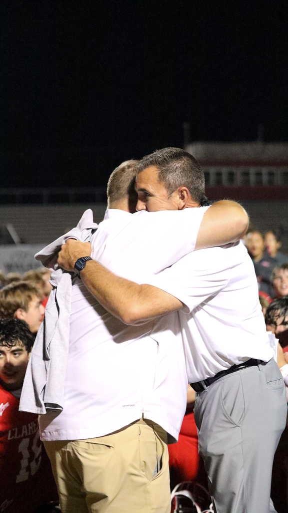 Coach Hurt hugs Superintendent Bryan Frazier after earning his 100th career win.